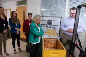 Visitors view a Mechanical Engineering beehive lifter project