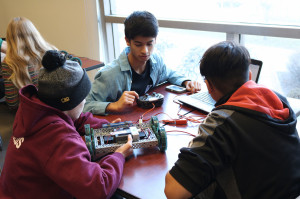 High school students work on their Vex Robotics vehicle