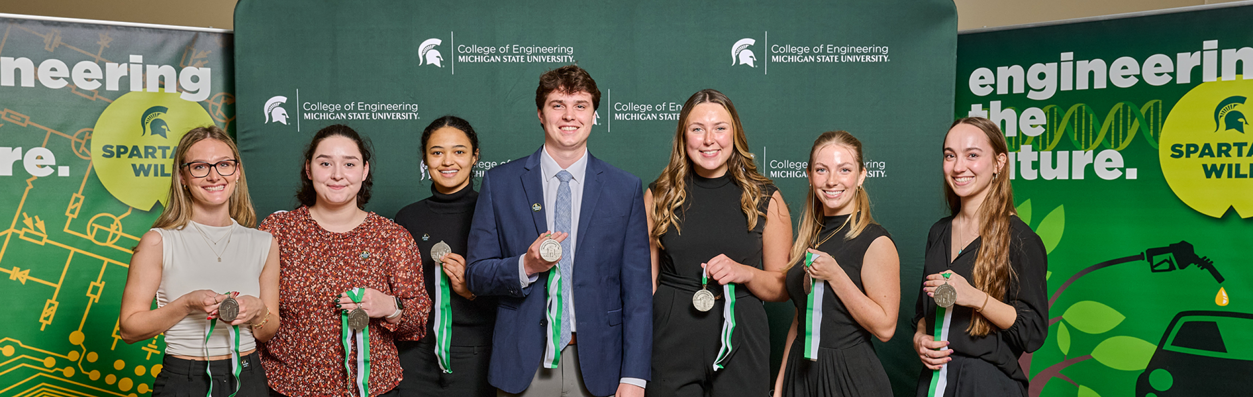 Students holding a Design Day award and smiling for a photo